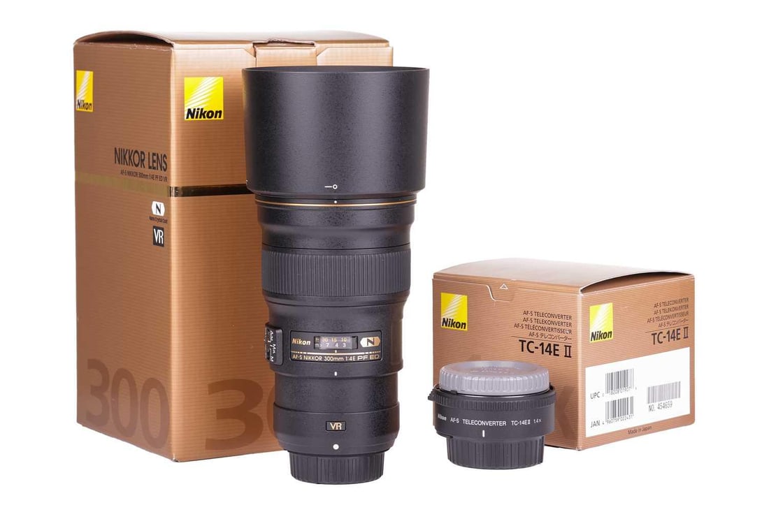 A Nikon Nikkor AF-S 300mm f/4E PF ED VR lens, together with a Nikon AF-S Teleconverter TC-14E II,: A Nikon Nikkor AF-S 300mm f/4E PF ED VR lens, together with a Nikon AF-S Teleconverter TC-14E II, each boxed with accessories and internal packaging, apparently unused. From a private collection, Hert