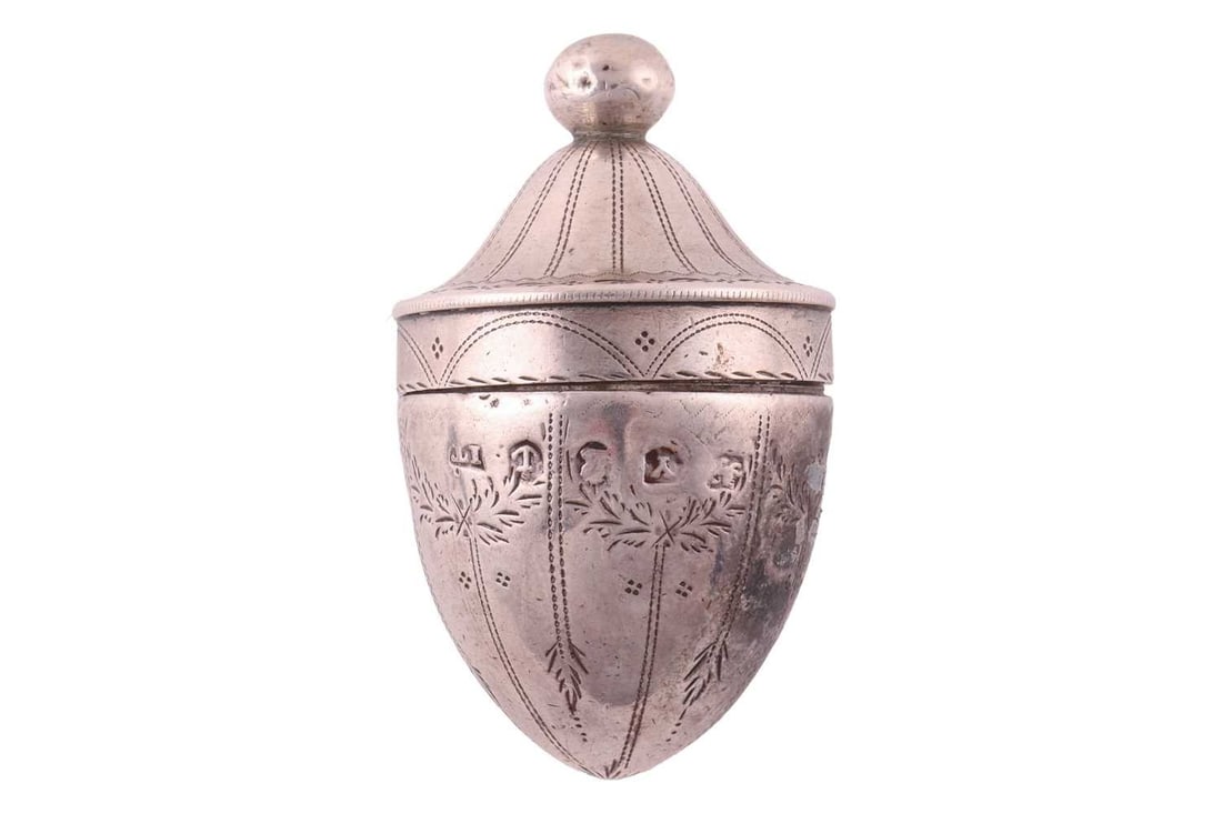 A George III silver nutmeg grater; attributed to Joseph Taylor, Birmingham 1795, acornshaped, with: A George III silver nutmeg grater; attributed to Joseph Taylor, Birmingham 1795, acornshaped, with brightcut engraved decoration and ball finial, 4.8 cm long, 17.3 grams.