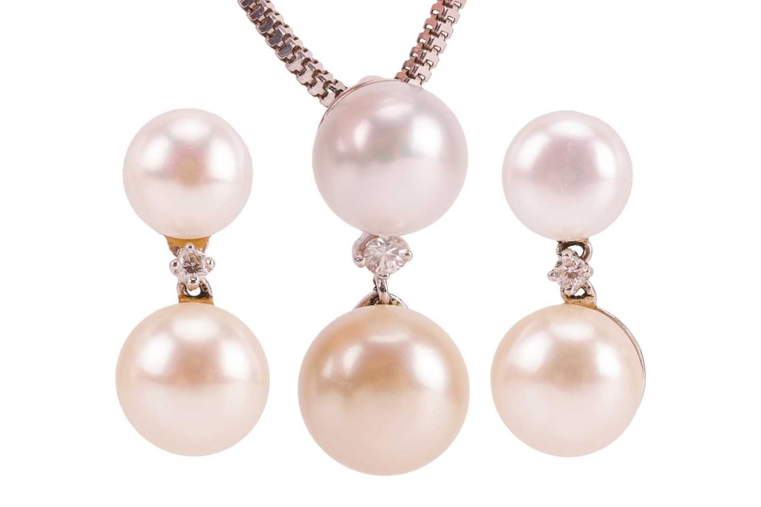 A cultured pearl pendant on chain and drop earrings ensemble; the pendant comprising a: A cultured pearl pendant on chain and drop earrings ensemble; the pendant comprising a cream-coloured round button pearl of 11.4 mm, suspending from a white-coloured pearl surmount with a diamond acce