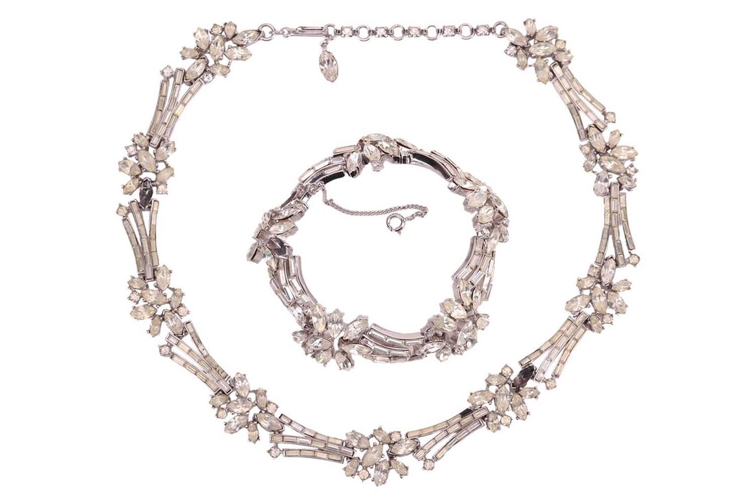Trifari - a paste-set necklace and matching bracelet set, circa 1960s; featuring marquise and baguet: Trifari - a paste-set necklace and matching bracelet set, circa 1960s; featuring marquise and baguette shaped pastes in closed-back settings to flexible links in white base metal with a signed hook cl