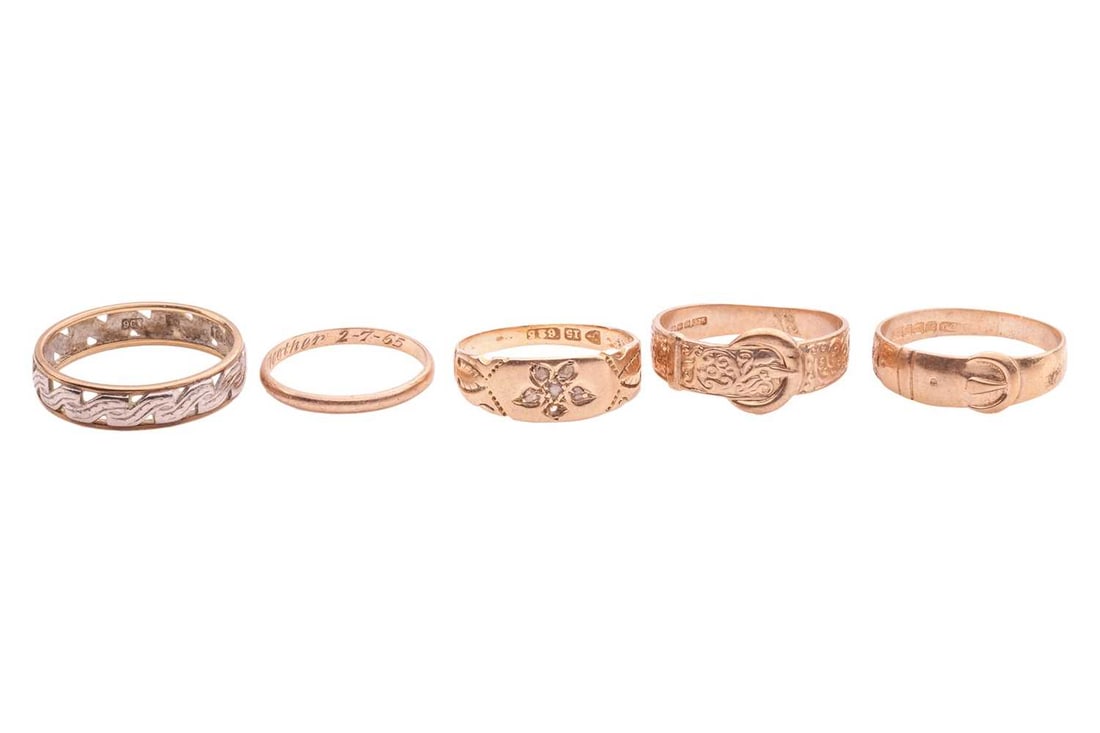 A group of five rings; the first an engraved band ring centred with a flower motif, grain set with f (1 of 2)
