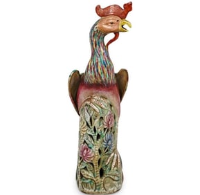 A Chinese porcelain statue depicting a vibrant glazed phoenix perched a top a pierced floral formed