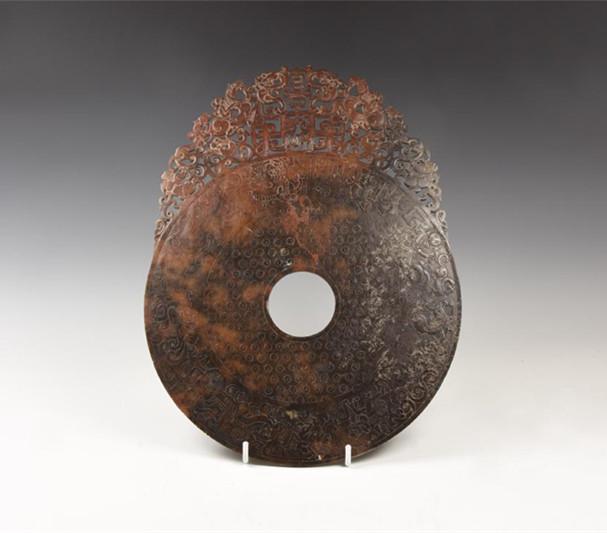 CHINESE CARVED AND ENGRAVED ROUNDEL: Chinese Carved and Engraved Roundel 20th century AD. A carved stone(?) roundel with openwork fringe of horsemen, lions, characters and scrolls, frieze of dragons and other beasts in low-relief to the 