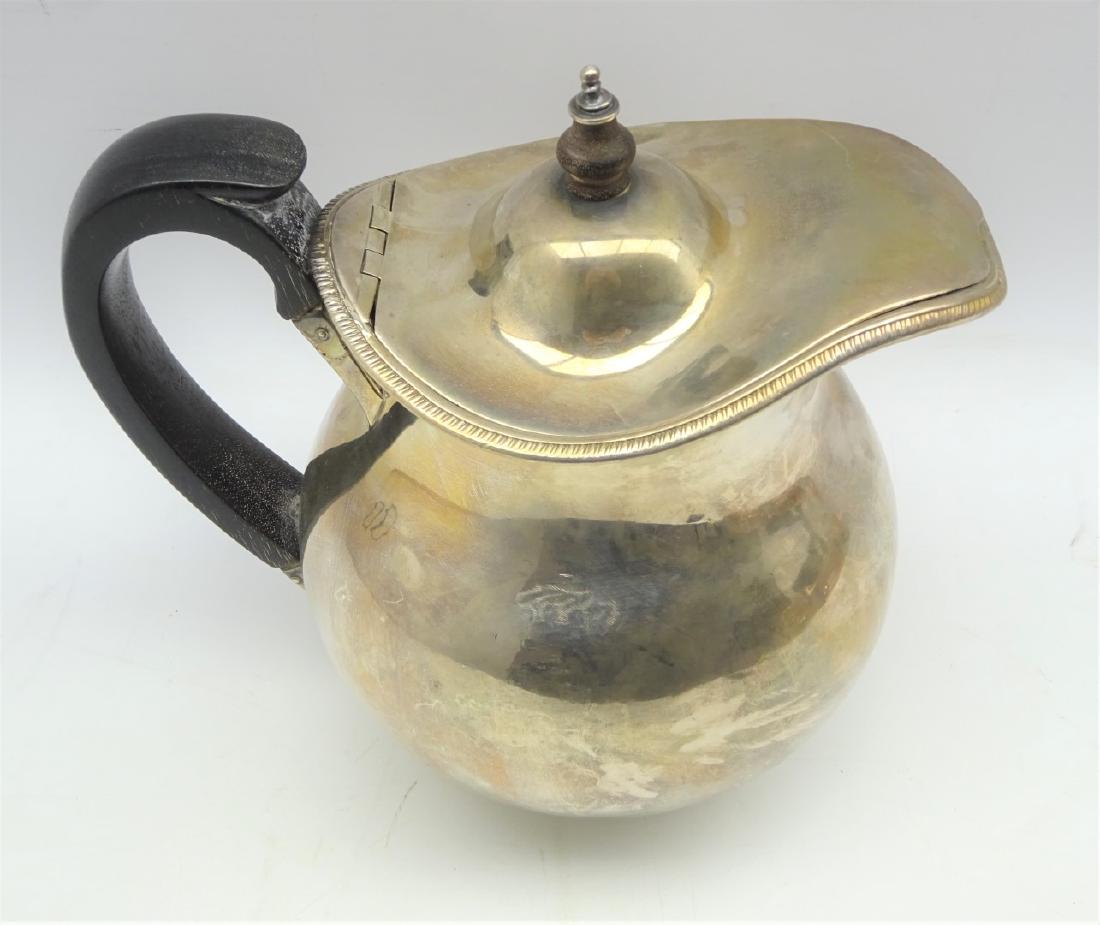 George III silver baluster water jug with hinged cover,: George III silver baluster water jug with hinged cover, blackwood handle and lift, engraved with a crest H 20 cms London 1802 Maker: Robert, David and Samuel Hennell 27.1 oz gross