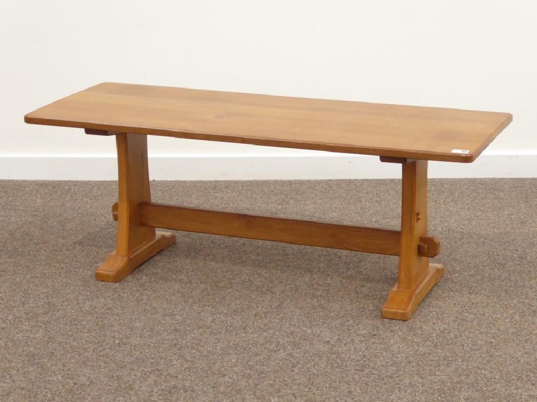 Craftsman made oak rectangular coffee table, shaped end: Craftsman made oak rectangular coffee table, shaped end supports on sledge feet connected by pegged stretcher, carved with Thistle signature, in the 'Mouseman' style, 120cm x 44cm, H46cm