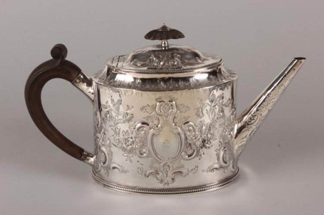 Hester Bateman George III Sterling Silver Teapot: hallmarked, London, 1784, H.B (Hester Bateman), of oval form with deep sides embossed with scrolls, flowers and foliage with wooden loop handle and beaded borders, total weight 479gm, h 16cm