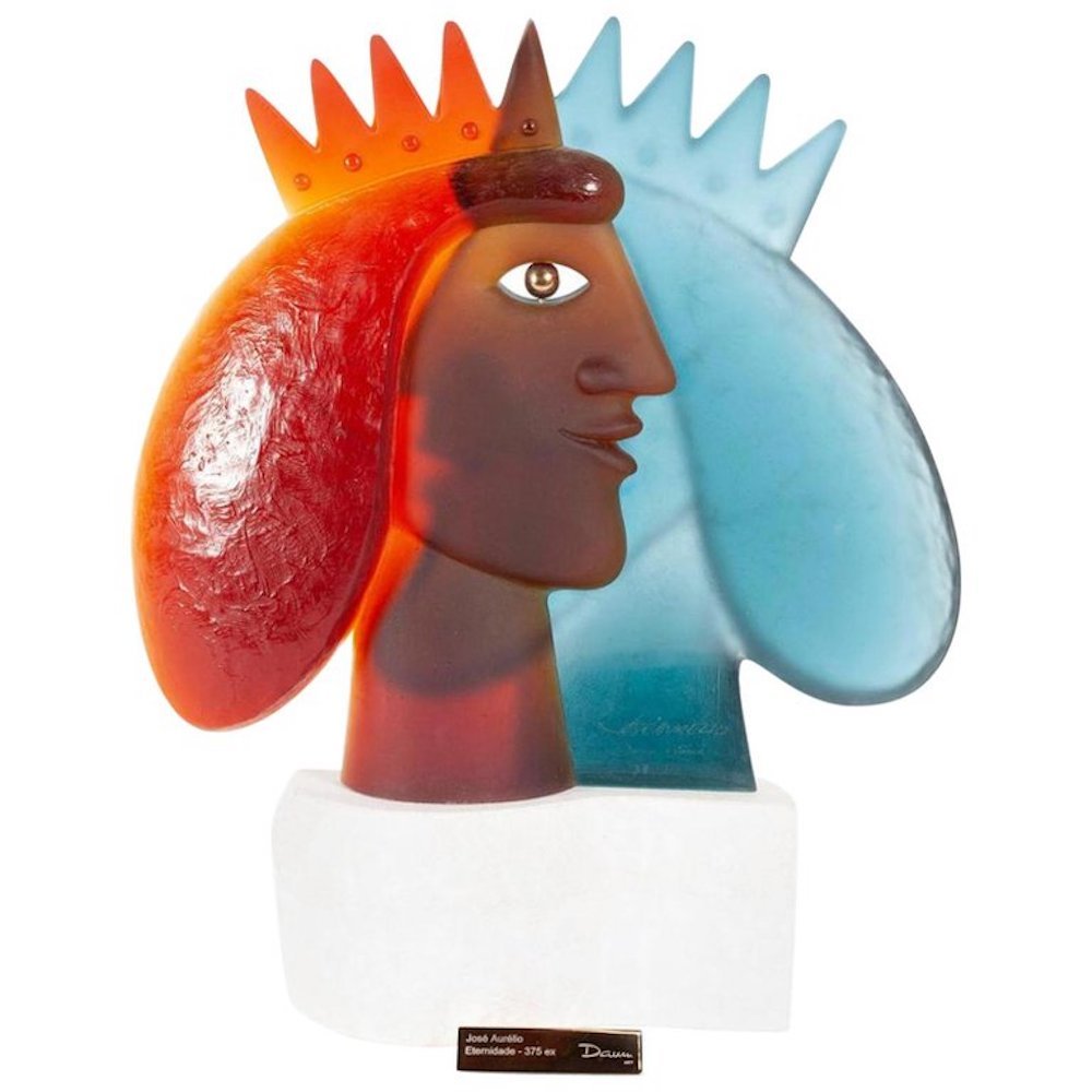 "Eternidade" by Jose Aurelio for Daum: Signed and numbered 37/375, opposing blue and red crystal faces wearing crown's sharing the same eye, mounted on stone base.