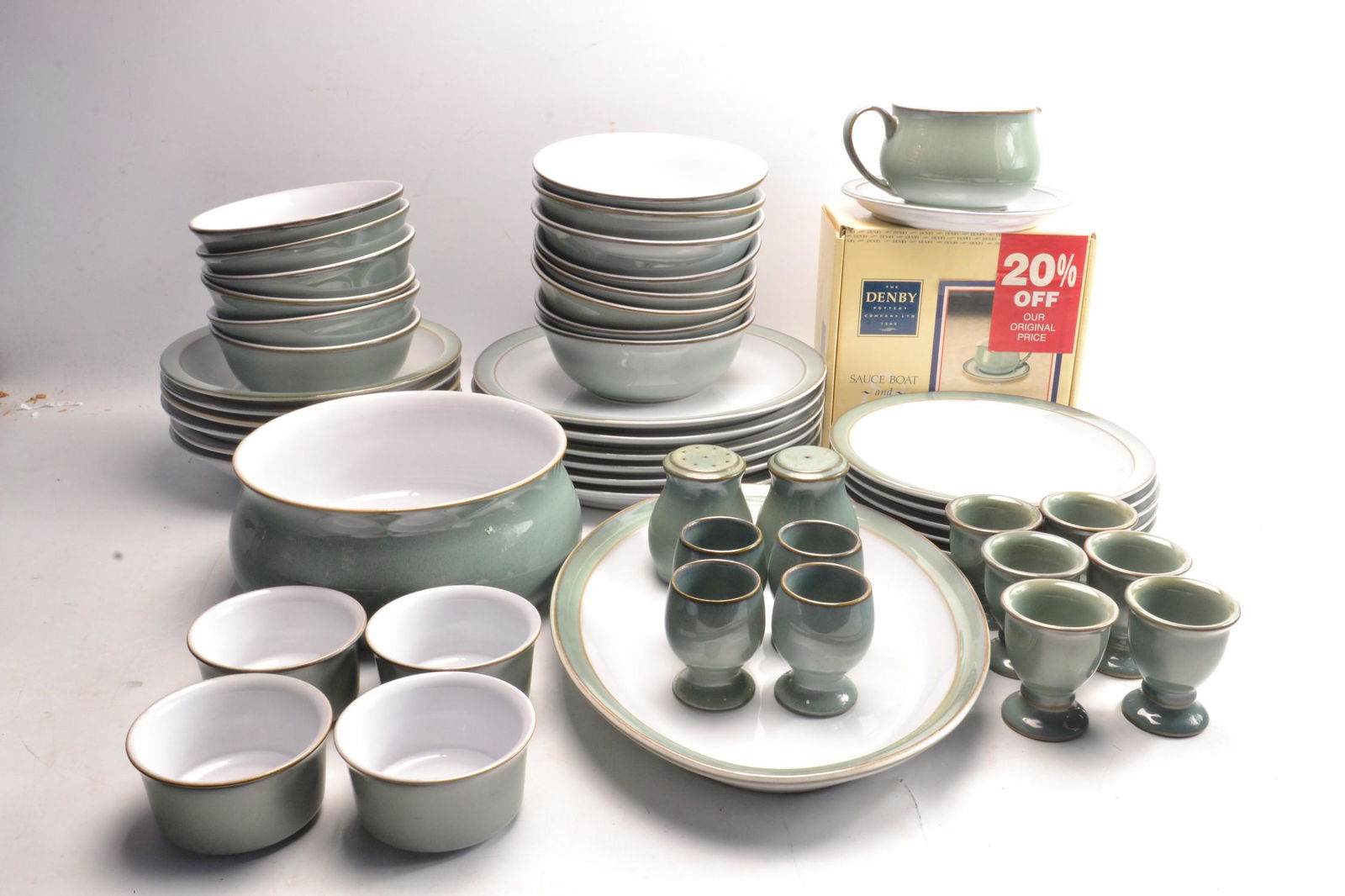 DENBY green glazed pottery dinner ware to include 6 of: DENBY green glazed pottery dinner ware to include 6 of each dinner plates, side plates, pudding bowls, soup bowls, side bowls, also ashet, gravy boat, salt and pepper pots, 4 ramekins, 10 egg cups and