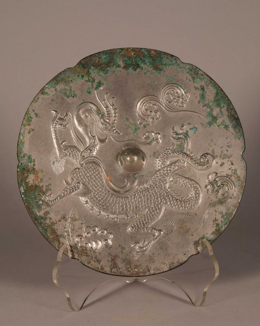 BRONZE MIRROR: Bronze mirror with a hand craft dragon design on the back; (Tang Dyn.); D:18.2cm