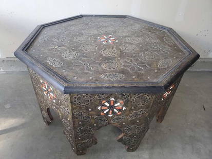 Elaborate decorated octagonal table: The wood table covered in thin metal lining and adorned with decorations. In good condition, minor losses to include two missing center metal inlays to the flowers on top, minor bends to the metal ove