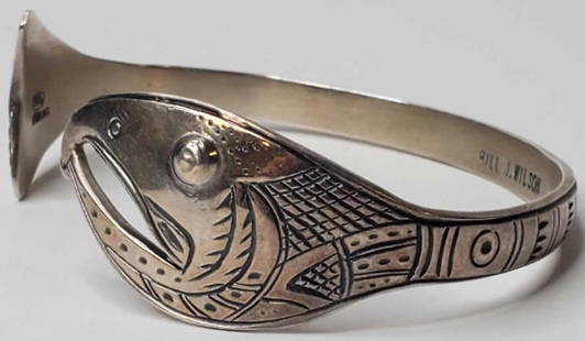 Bill Wilson Tlingit Salmon motif bracelet: The bracelet in excellent condition with well executed salmon theme, signed on inner band Bill J. Wilson and MAG sterling. Weighs 27.6 grams. Bracelet measures 2.75" at widest point.