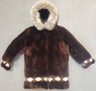 Mouton and wolf fur embroidered parka: The vintage parka in very good condition with wolf fur ruff and embroidered leather accents. Measures 30.75" long not including hood, 18" from shoulder cuff to shoulder cuff, arms 21.5" from top of sh