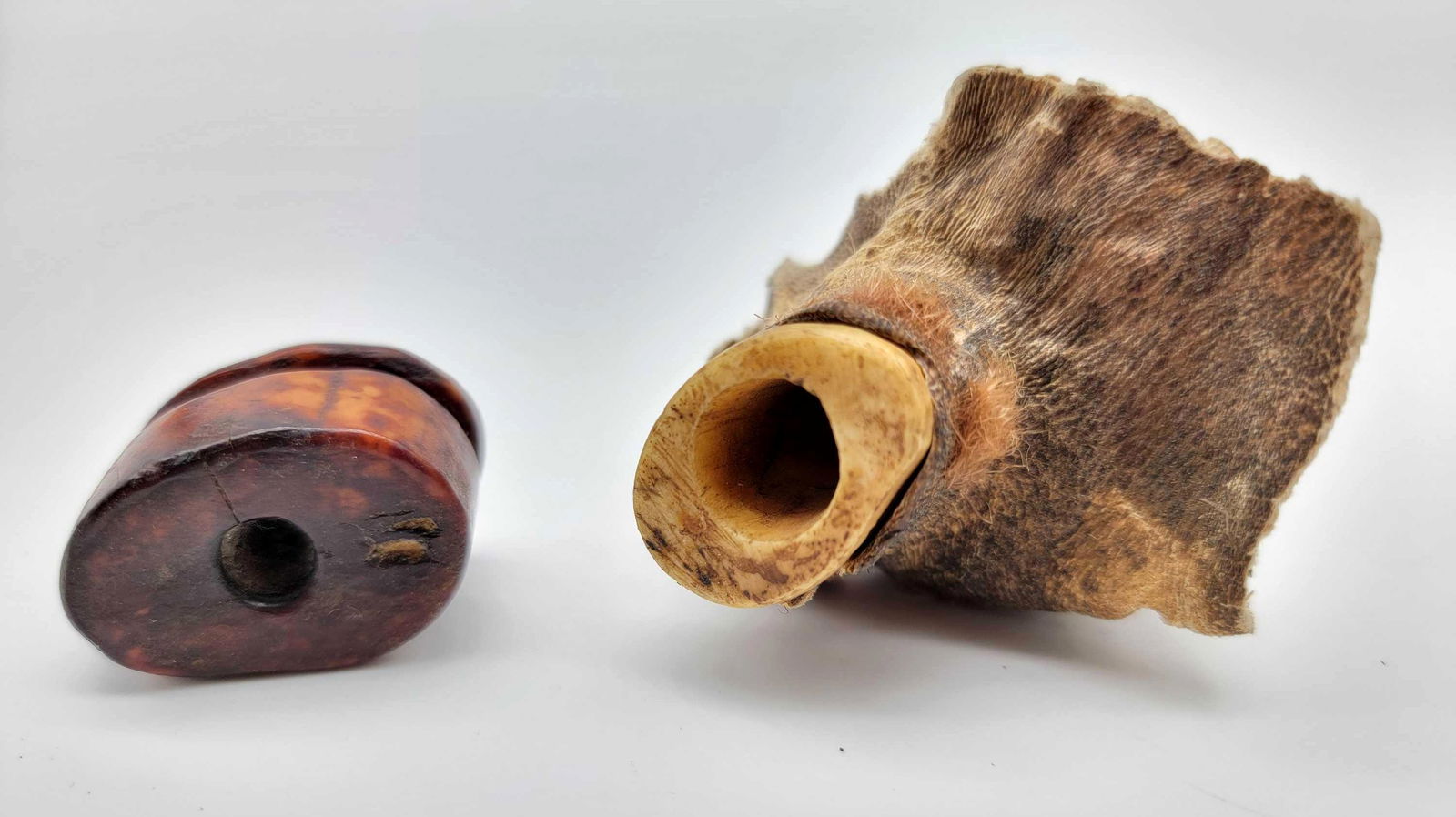 Eskimo Seal Skin Float & Oil Container Inflation Plug A: Two Eskimo inflation plugs; the first a bone example for a sealskin float with hide remnants still attached, the other fossil Walrus tusk and likely for an oil bag.