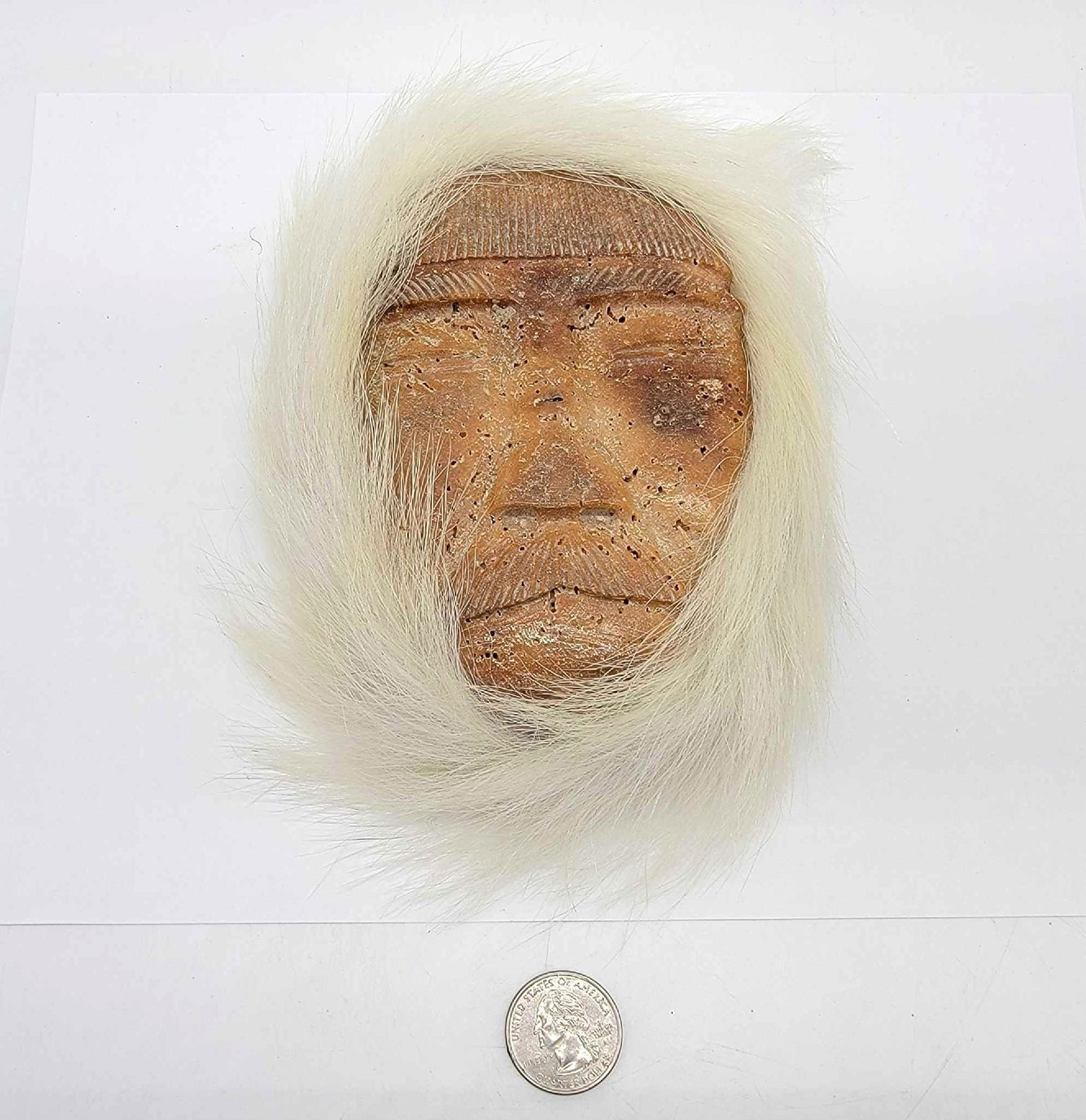 Fossil Whalebone Eskimo Carved Mask w/ Polar Bear Fur R: A slice of whalebone vertebra carved to depict an Eskimo gentleman in a parka, lined with polar bear fur and in good condition with no readily visible maker's marks. Measures approximately 8"