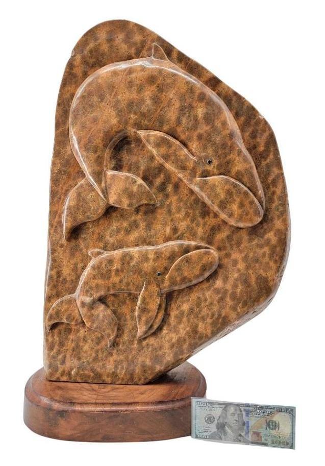 Large Stone Carving of Humpback Whales: A relief carved stone sculpture depicting two humpback whales. It sits on a walnut wood base made signed and dated circa 2011 by the artist, Michael Scott. Measures approximately 26" tall x 17"