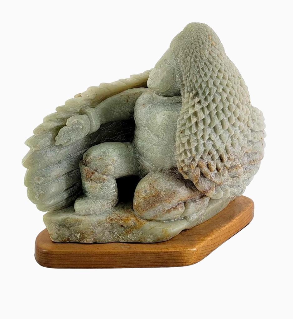 Soapstone Carving of Native American Dancer by Michael: A large carved soapstone sculpture depicting a Native American wearing a cape in the form of an Eagle and performing a dance. Signed by the Alaskan artist Michael Scott and dated 1991. Measures approx
