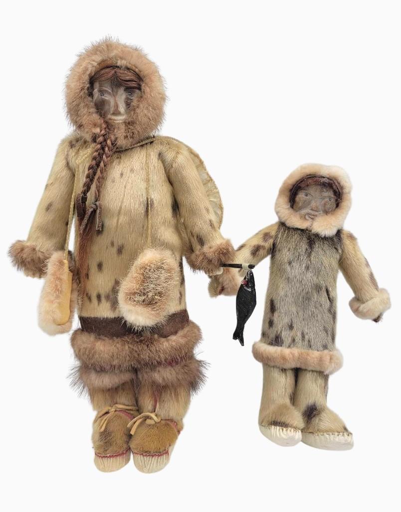 Two Yup'ik Eskimo Dolls by Rosalie Bunyan in Seal Fur G: A pair of matching Yup'ik dolls by the Hooper Bay doll maker Rosalie Bunyan (b.1956). These fine examples are fully clothed in seal and other natural fur garments, their faces hand-carved from fossil