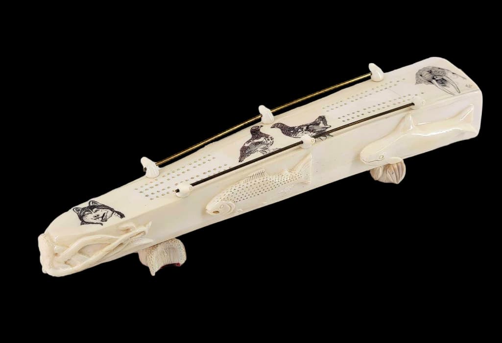 Scrimshaw Walrus Tusk Cribbage Board by Richard Freeman: A highly detailedÂ walrus tusk cribbage board signed "RF",Â by the prominentÂ Afognak Island, Alaska, Aleut artist Richard Freeman. The scrimshaw top depicts a husky sled dog, a pair of