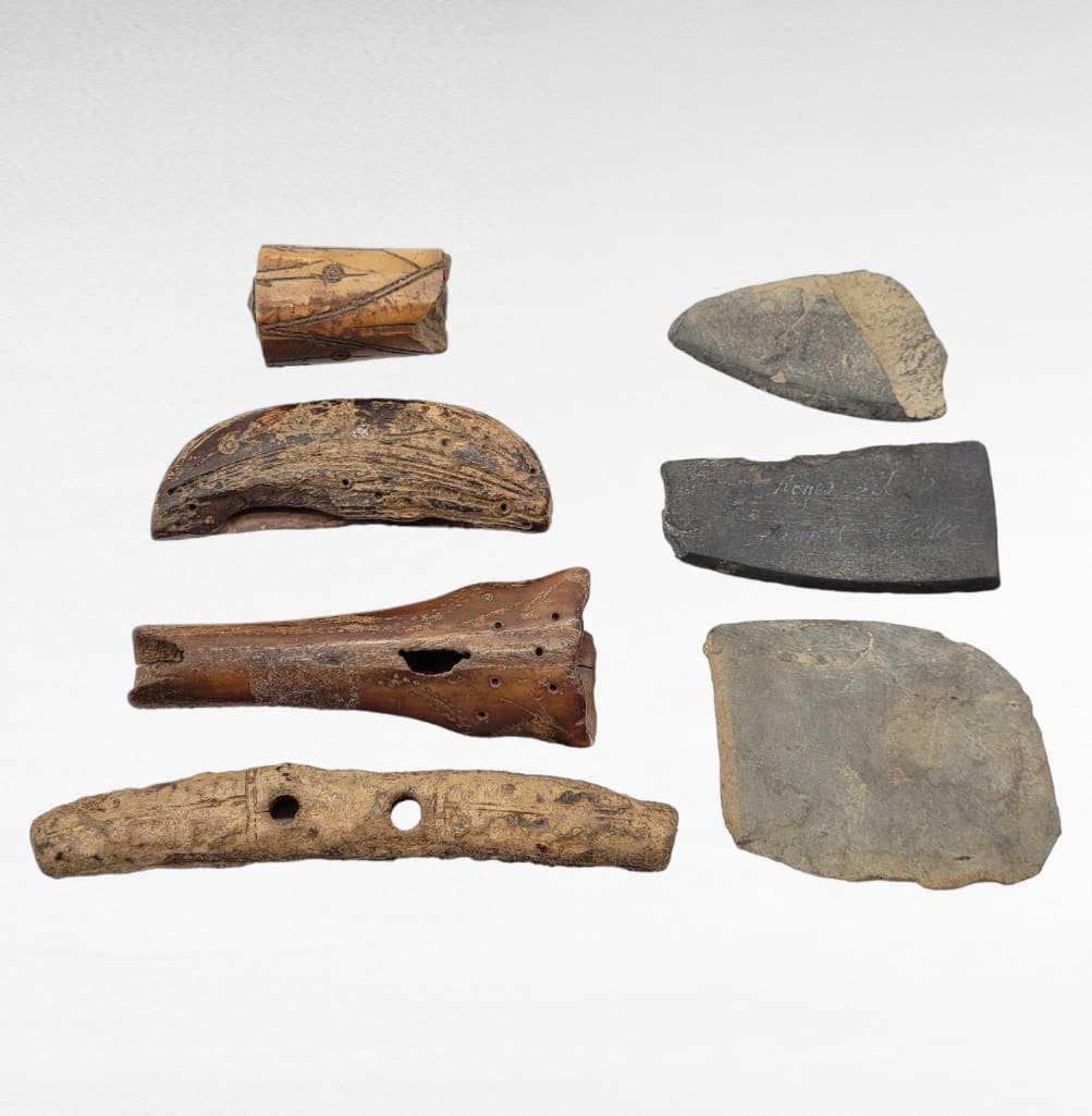 Old Bering Sea & Punuk Paleo-Eskimo Artifacts: A group of Old Bering Sea & Punuk period Paleo-Eskimo artifacts to include a drag handle, ulu handles, ulu blades, and more. All objects aside from the slate ulu blades are carved from walrus tusk