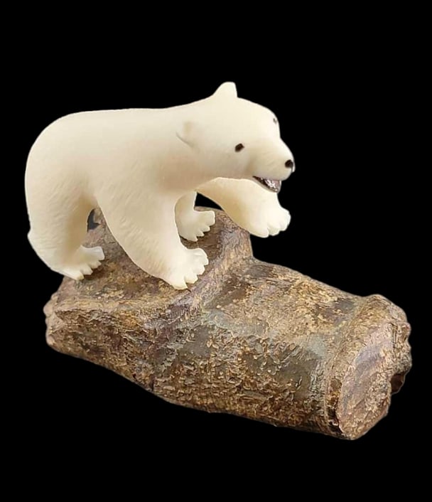 Walrus Tusk Polar Bear Carving on Artifact Base by W. B: A well-carved Yup'ik walrus tusk polar bear with incised fur accents, taking a tentative step upon a tusk artifact base. Signed on the underside by "W. Booshu," likely for one of the Gambe