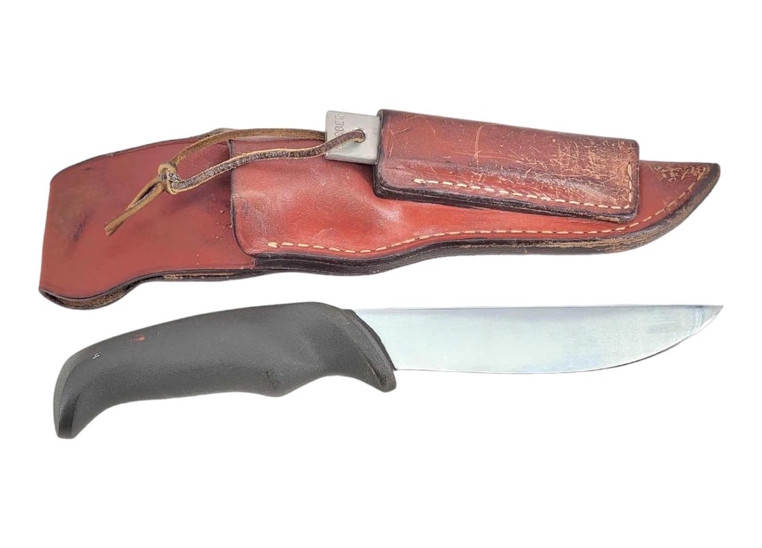 Fixed Straight Blade Hunting Knife w/ Leather Sheath: A fixed straight blade hunting knife with black composite ergonomic handle. Knife blade is unbranded, and handle exhibits small surface abrasions as photographed. Housed in a Gerber Magnum Hunter leat