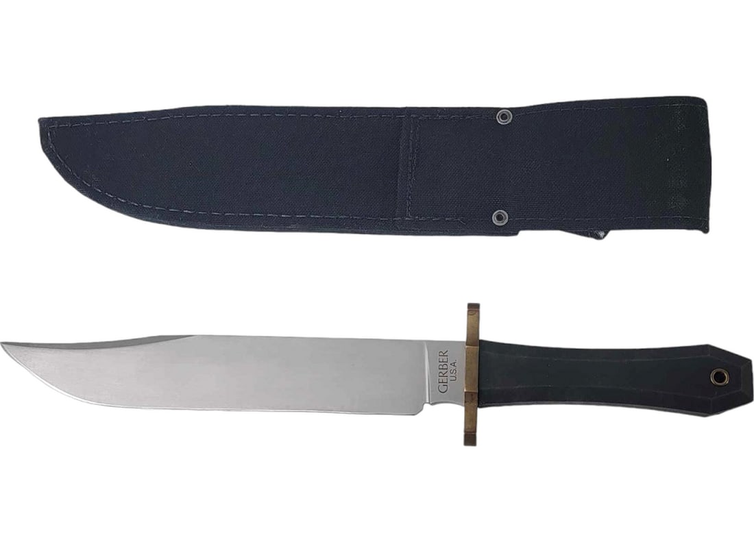 Gerber Australian Utility Bowie Knife w/ Sheath: An Australian Utility Bowie knife marked for Gerber on the ricasso. Circa 2011-2020, the knife tang is concealed within a rubber handle fronted with a double brass guard and terminated with a lanyard 