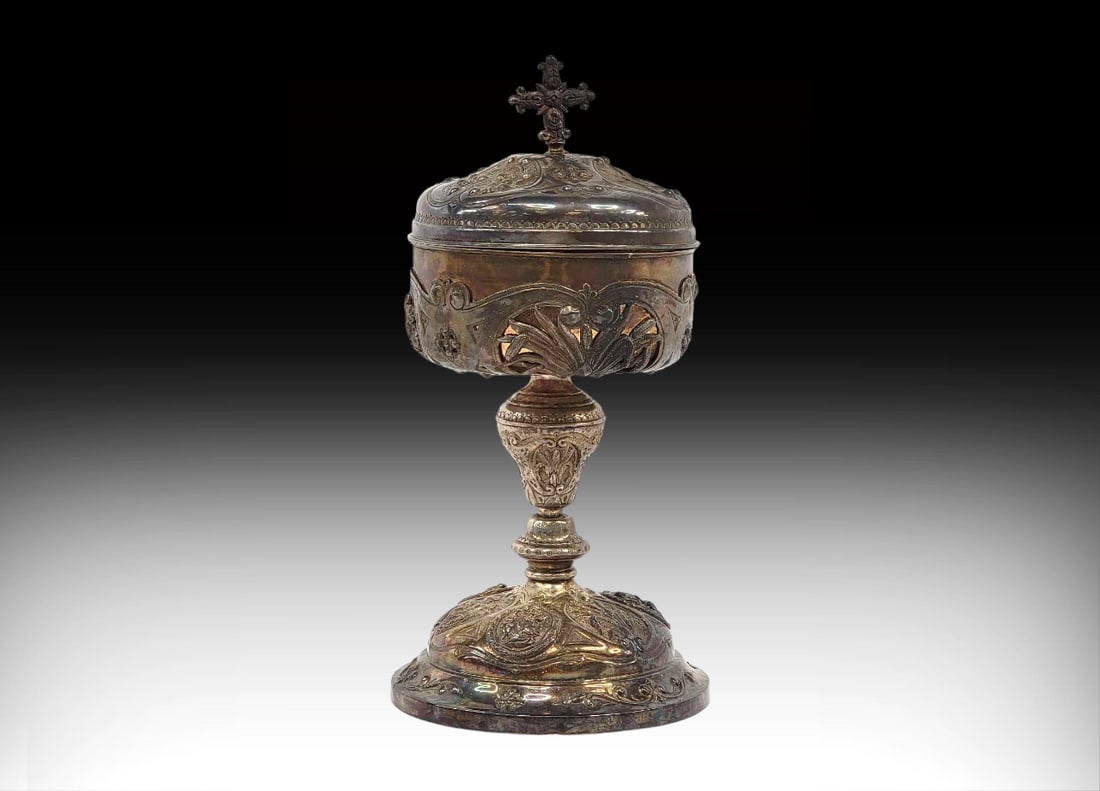 Large Antique French Sterling Silver Ciborium: A French 19th Century solid sterling silver ciborium with a lovely repoussé and hammered lid depicting vignettes of religious figures, accented by foliate elements of grapes and cattails and topped w