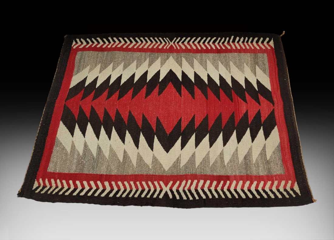 Navajo Ganado Eye Dazzler Rug: A handwoven Ganado rug from the Navajo Nation in Arizona featuring a central eye-dazzler pattern with full red and black frame, two sides with cream repeating chevrons. Measures approximately 47.5"