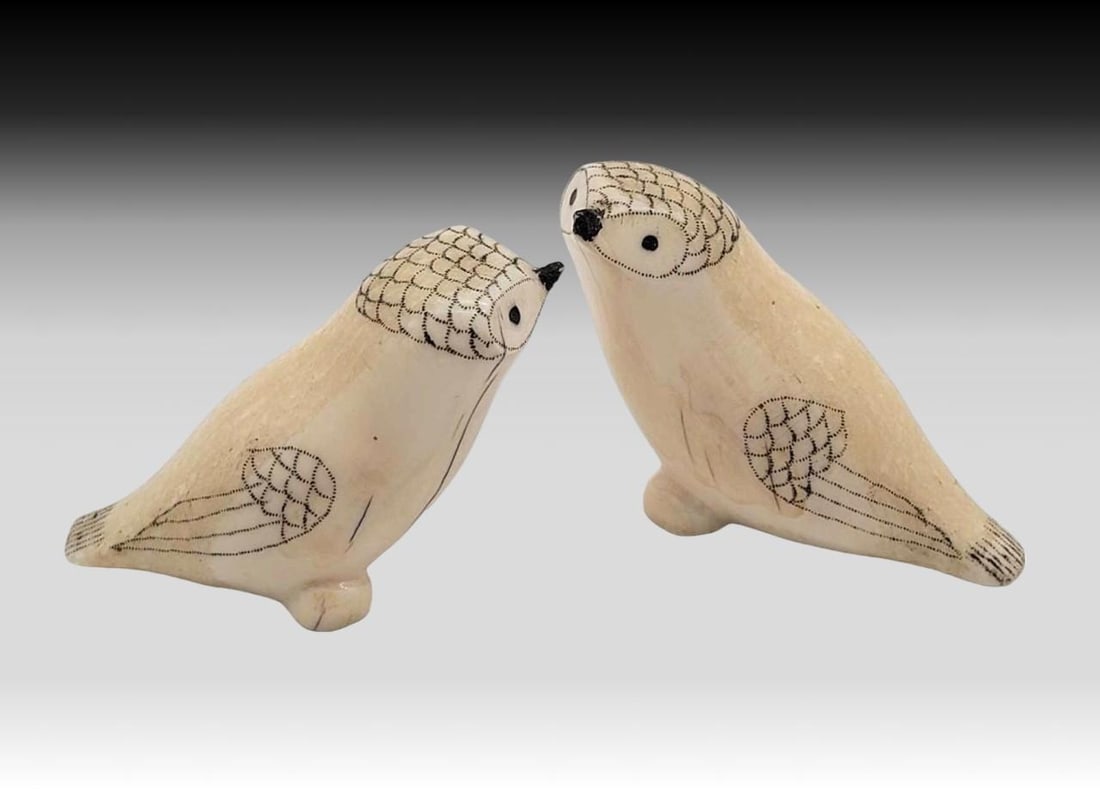 Walrus Tusk Scrimshaw Arctic Owl Figurines: A pair of adorable Arctic owls, each carved from walrus tusk and featuring delicate scrimshaw feathers upon their heads and wings. Each one has minor surface imperfections as shown, and the largest ow