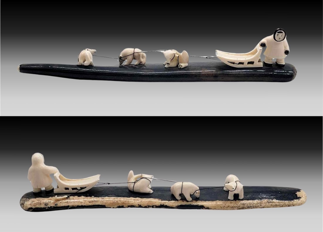 Walrus Tusk Sled Dog Team on Fossilized Tusk Base - Tim Alowa: A trio of husky dogs with their musher and sled, all carved from walrus tusk and accented with scrimshaw details. The team is mounted upon a deeply fossilized black walrus tusk; signed on the undersid