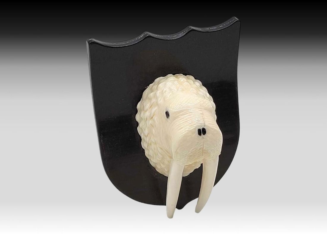 Walrus Tusk & Baleen Walrus on Baleen Plaque - Dean Kulowiyi: A walrus tusk carved walrus face, inset with baleen facial features; mounted upon a baleen plaque. Signed en verso circa 1999 for Yup'ik artist Dean Kulowiyi of Savoonga, St. Lawrence Island, Alas