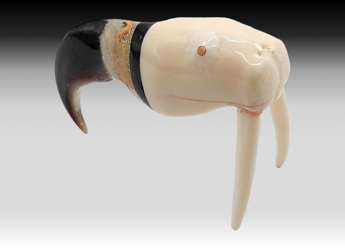 Walrus Tusk, Baleen & Polar Bear Claw Walrus Figurine: A walrus tusk carved walrus head with inset tusks, attached with a ring of baleen to a polar bear claw. Measures approximately 3.5" x 1" x 2.25" tall.