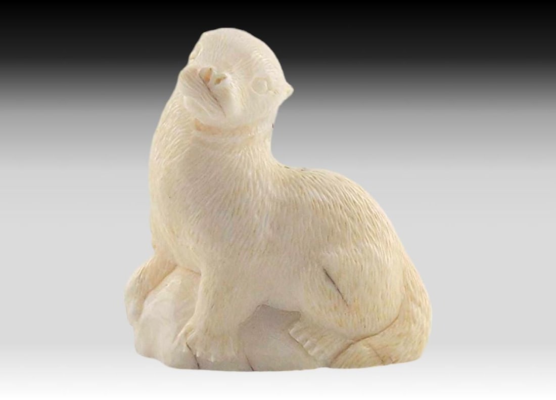 Walrus Tusk & Baleen River Otter - William Soonagrook: A walrus tusk carved and incised river otter, sitting upon a rocky base. Signed on the underside by Central Siberian Yup'ik carver William Soonagrook of Gambell, St. Lawrence Island, Alaska, circa