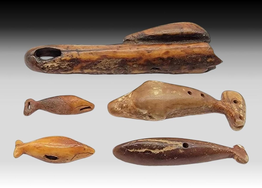 Thule Whale Form Toggles, Charms, etc.: Five Thule culture artifacts carved from ancient walrus tusk. Includes four zoomorphic whale carvings and one piece with a whale perched on top. The pieces have various drilled holes for use as toggle
