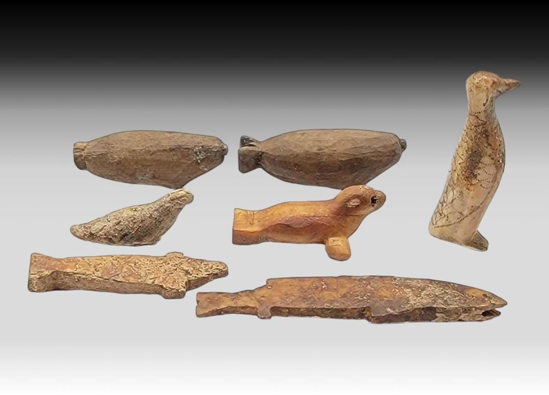 Eskimo Toys & Scrimshaw Carvings: Seven 19th-century or earlier Eskimo fossilized bone and walrus tusk toys and carvings, including zoomorphic whales, seals, and puffins; the larger seal is missing a piece, as photographed. The larges