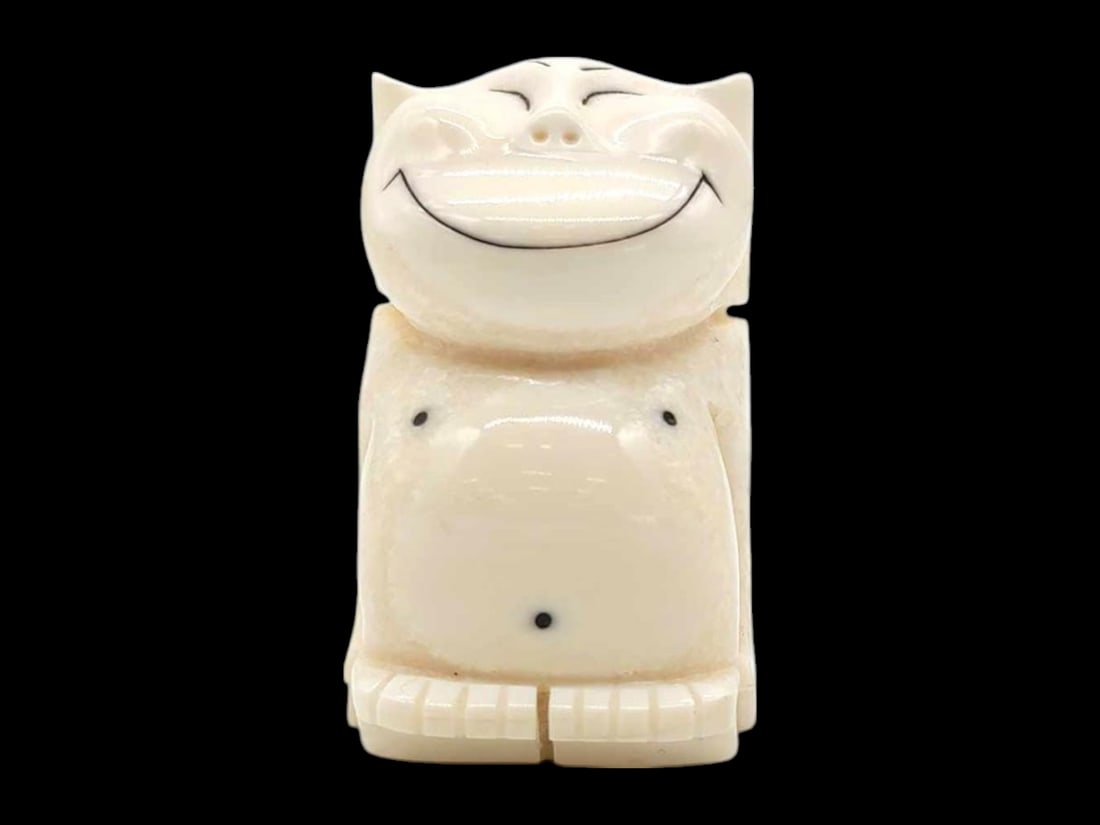 Warus Tusk, Baleen & Scrimshaw Billiken Figurine: A cute-as-a-button diminutive billiken figurine carved from walrus tusk, featuring carefully incised facial features and toes, and accented with scrimshaw and inset baleen dots. Measures approximately