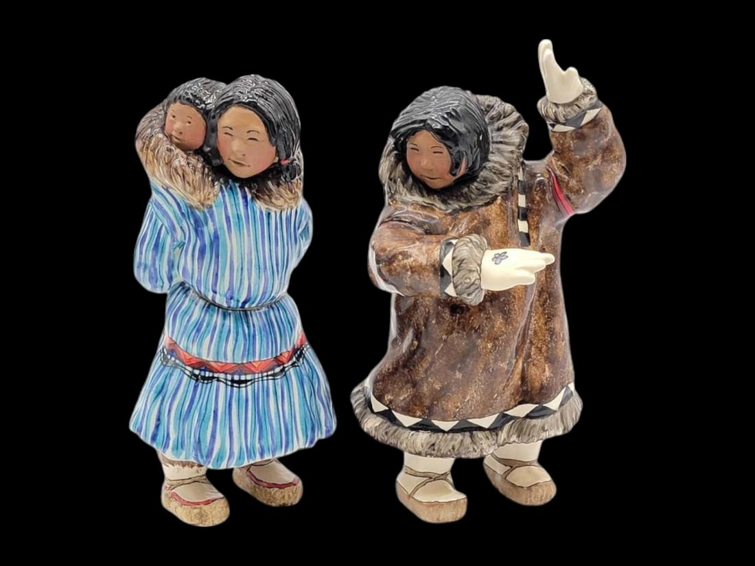 C. Alan Johnson Ceramic Figurines - Anna & Mary: Two ceramic sculptures of Alaska Native peoples by the late Alaskan artist C. Alan "Bud" Johnson (1926-2013). The works are "Anna," a woman in blue striped amauti with baby, and "M