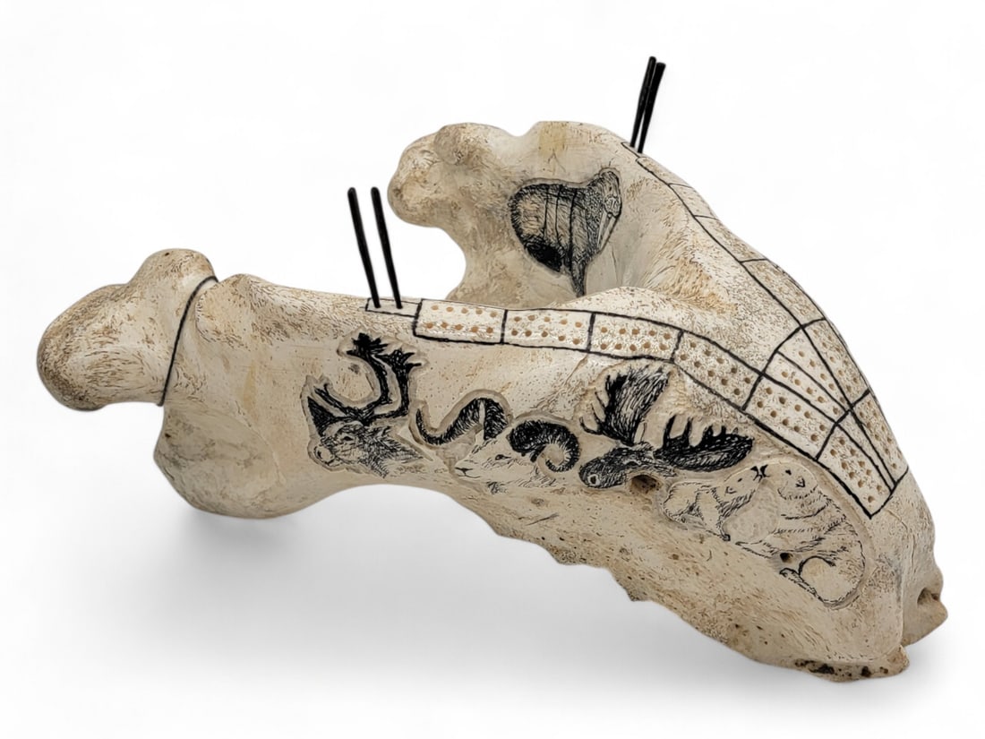 Scrimshaw Walrus Jawbone Cribbage Board - Whittam Adams: A cribbage board carved from the jawbone of a Pacific walrus (Odobenus rosmarus) by Whittam Adams that is elegantly accented along the sides with scrimshawed imagery of Alaska wildlife including moose