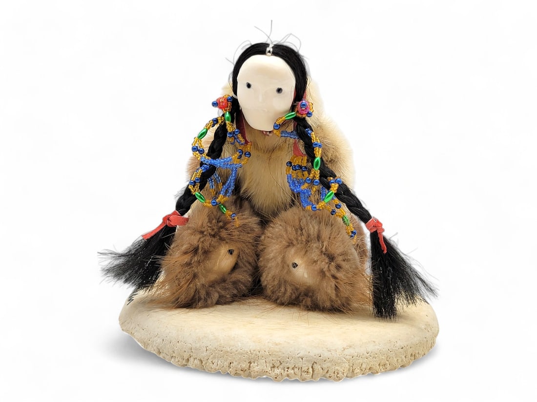 Beulah Oittillian "Doll with Masks": A stunning doll by Yup'ik doll maker Beulah Oittillian of a figure wearing and holding carved walrus tusk masks with delicate details, clothed in a sealskin parka with fur accents and colorful beads; 