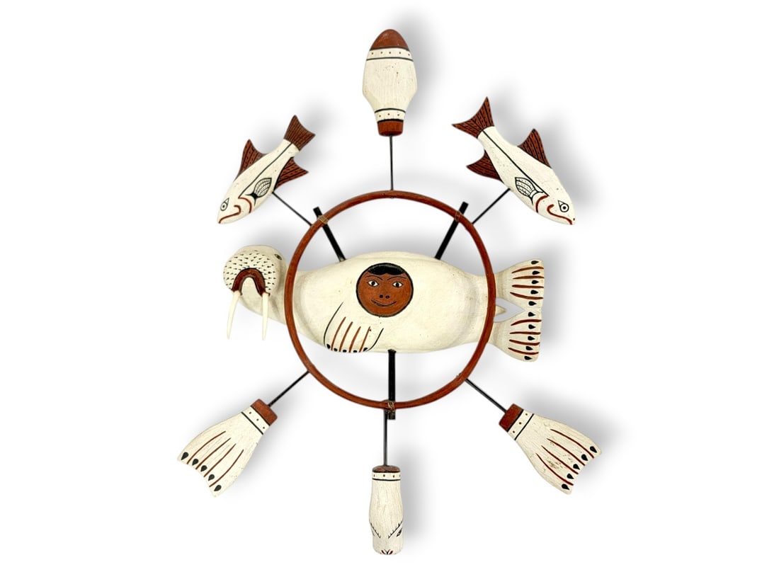 Nunivak Yup'ik Polychrome Figural Spirit Wheel: A polychrome painted carved wood Yup'ik spirit wheel depicting the central design of a walrus figure with a human face within the belly area. Surrounding the walrus are six effigies attached to a bent