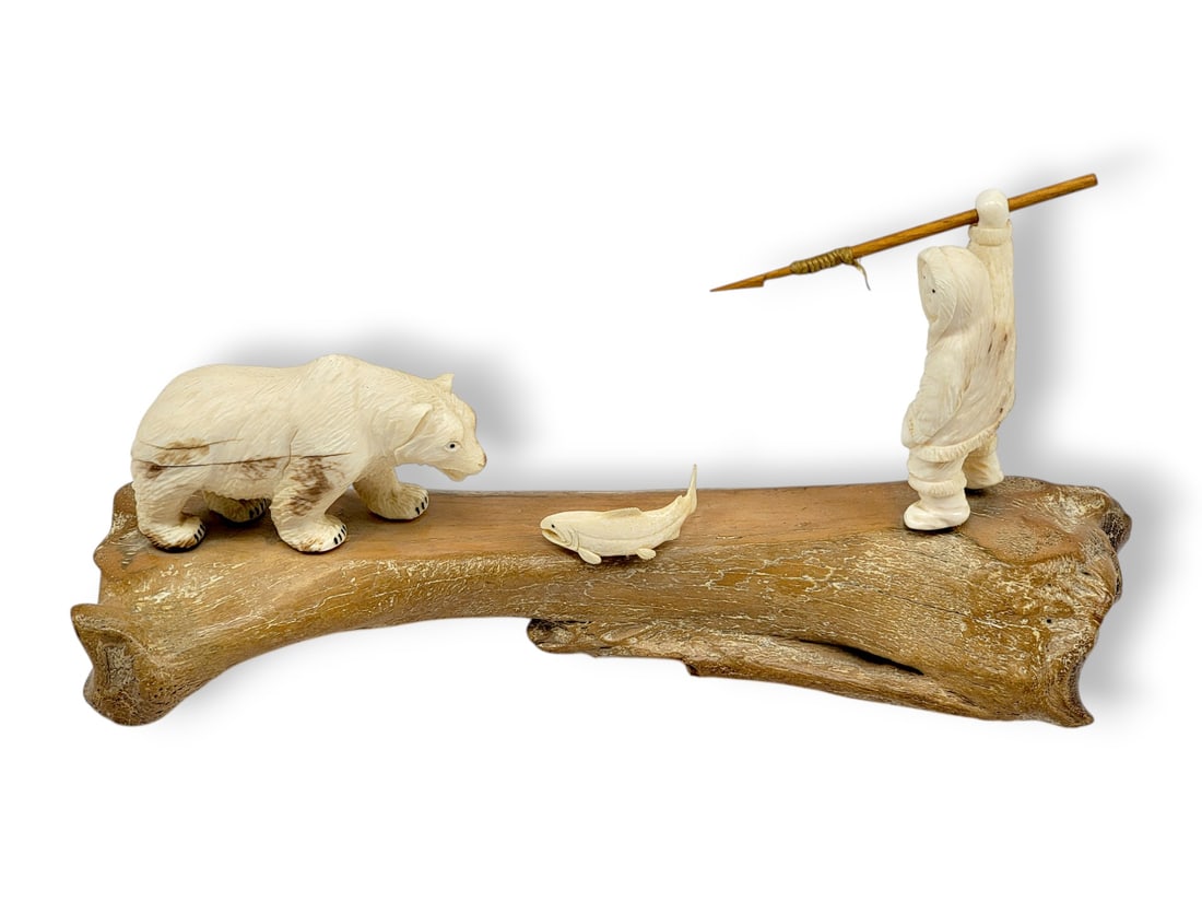 Grizzly Hunt Walrus Tusk Diorama - Eddy Syngoc: An exceptional and large diorama crafted of walrus tusk depicting a grizzly bear advancing on a fish, while a hunter has his sights set upon the bear; the hunter stands with his left foot forward, rig