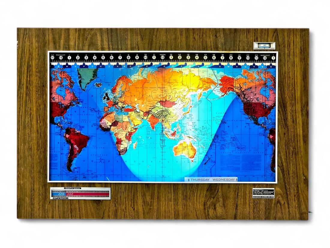 Kilburg Geochron World Clock: A vintage Kilburg Geochron model KG-110-60 world clock, featuring a brightly colored, mechanically driven time zone map mounted on a faux woodgrain panel. This wall-mounted device displays real-time g