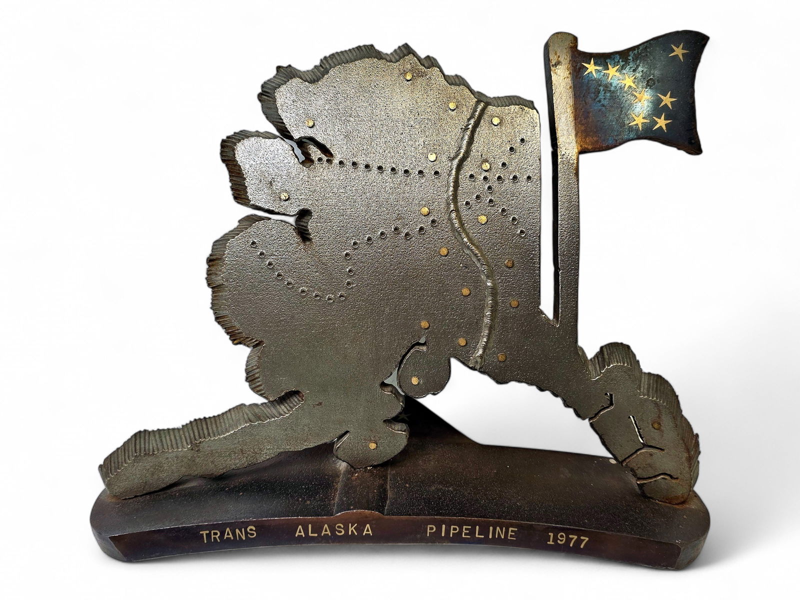 Trans-Alaska Pipeline Sculpture w/ Alaska Flag: A metal sculpture crafted from pipeline steel to commemorate the completion of the Trans-Alaska Pipeline in 1977. The sculpture, shaped to mimic the State of Alaska, features an Alaska state flag