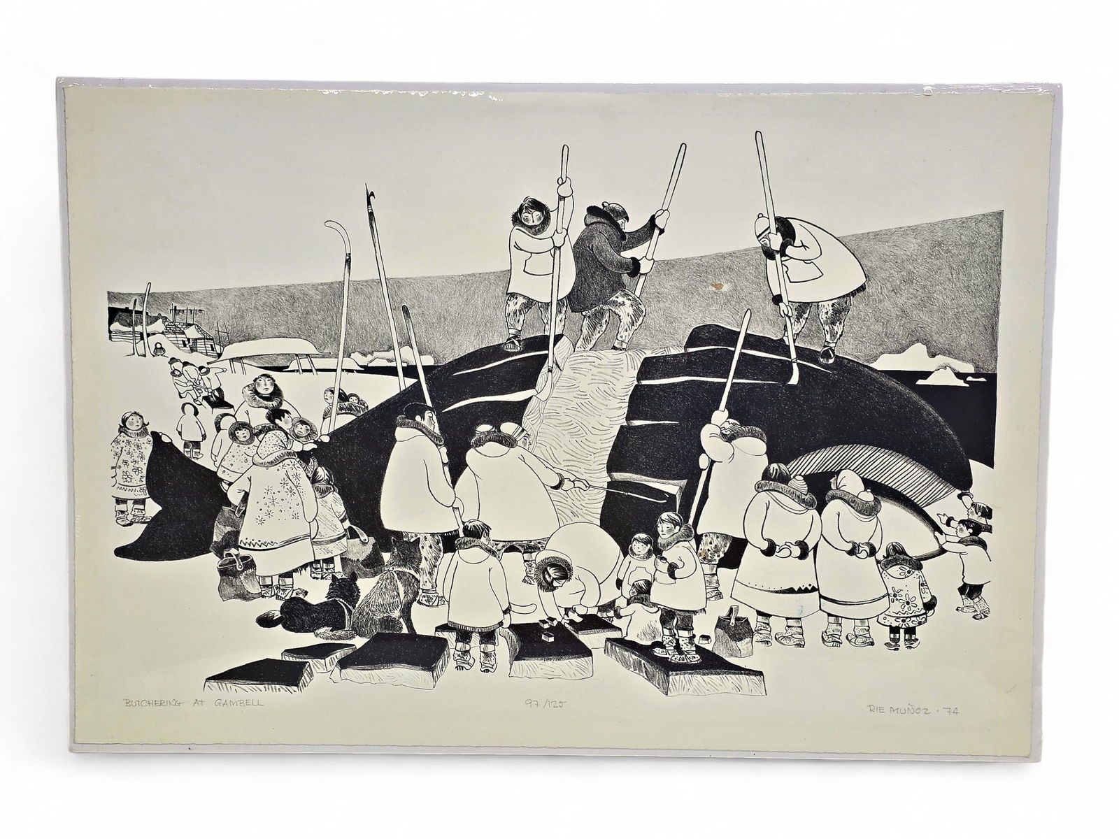 Rie Munoz "Butchering at Gambell" Stone Lithograph: A signed and numbered 97/125 stone lithograph entitled "Butchering at Gambell" by Alaska artist Rie Munoz (1921-2015). The c.1974 piece, in shades of black, depicts an entire village having descended
