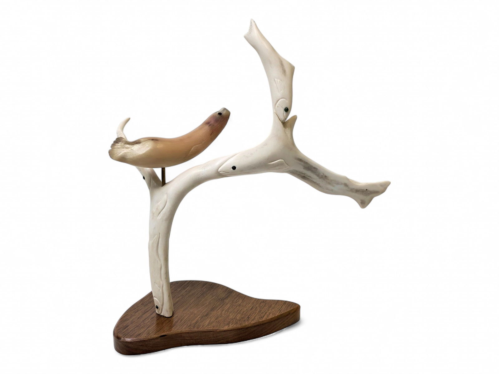 Diorama of Seal Hunting Salmon - Karen Olanna: A sculpture depicting a tree of fish carved from a bleached and polished antler, also featuring an applied seal carved from muskox horn; the seal and fish have inlaid eyes of baleen eyes, and the