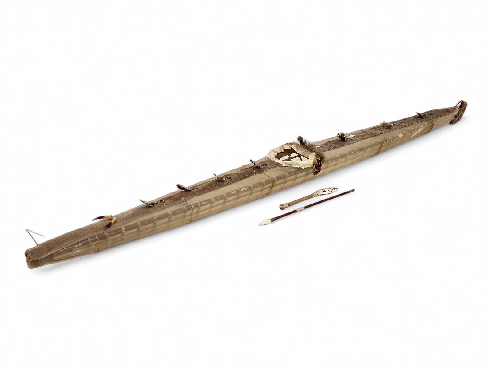 A Large Aleut Kayak Model: A finely constructed model baidarka (kayak), crafted with a wood frame and covered in seal gut, with additional animal hide elements, reflecting traditional Unangax? watercraft construction. The