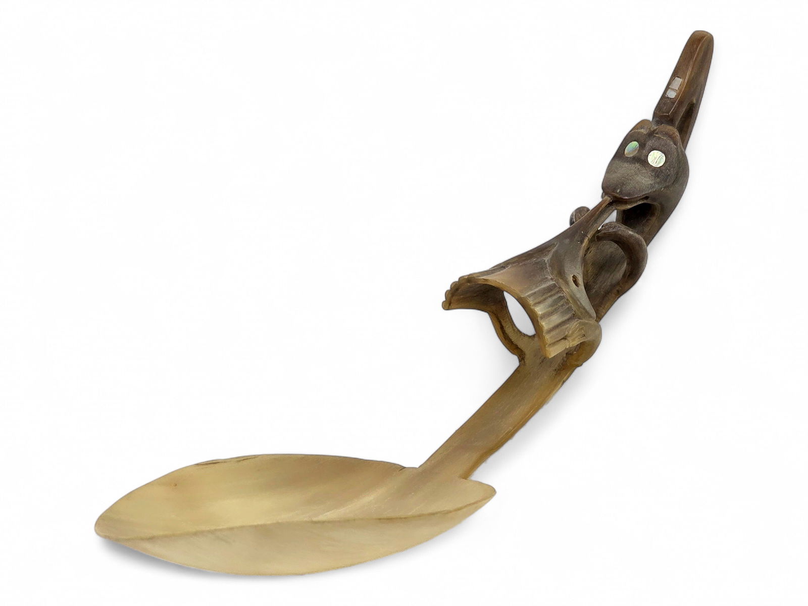 Tlingit Ceremonial Sheep Horn Figural Spoon: A ceremonial Tlingit spoon carved from mountain goat or sheep horn featuring a figural hollow handle with inlaid abalone or mother-of-pearl eyes, wide snout, and holding the beak of a bird within its