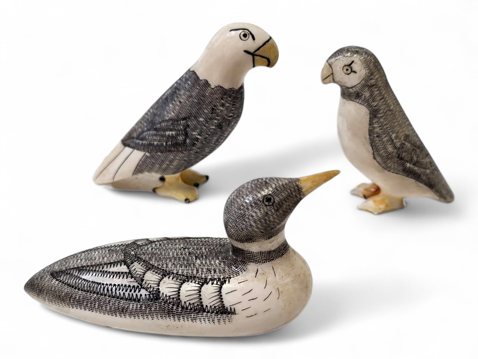 Peter and Joseph Mayac King Island Walrus Tusk Avian Carvings: A charming group of three walrus tusk avian carvings by members of the celebrated Mayac family of King Island, Alaska, each rendered with finely executed scrimshaw and keen attention to the
