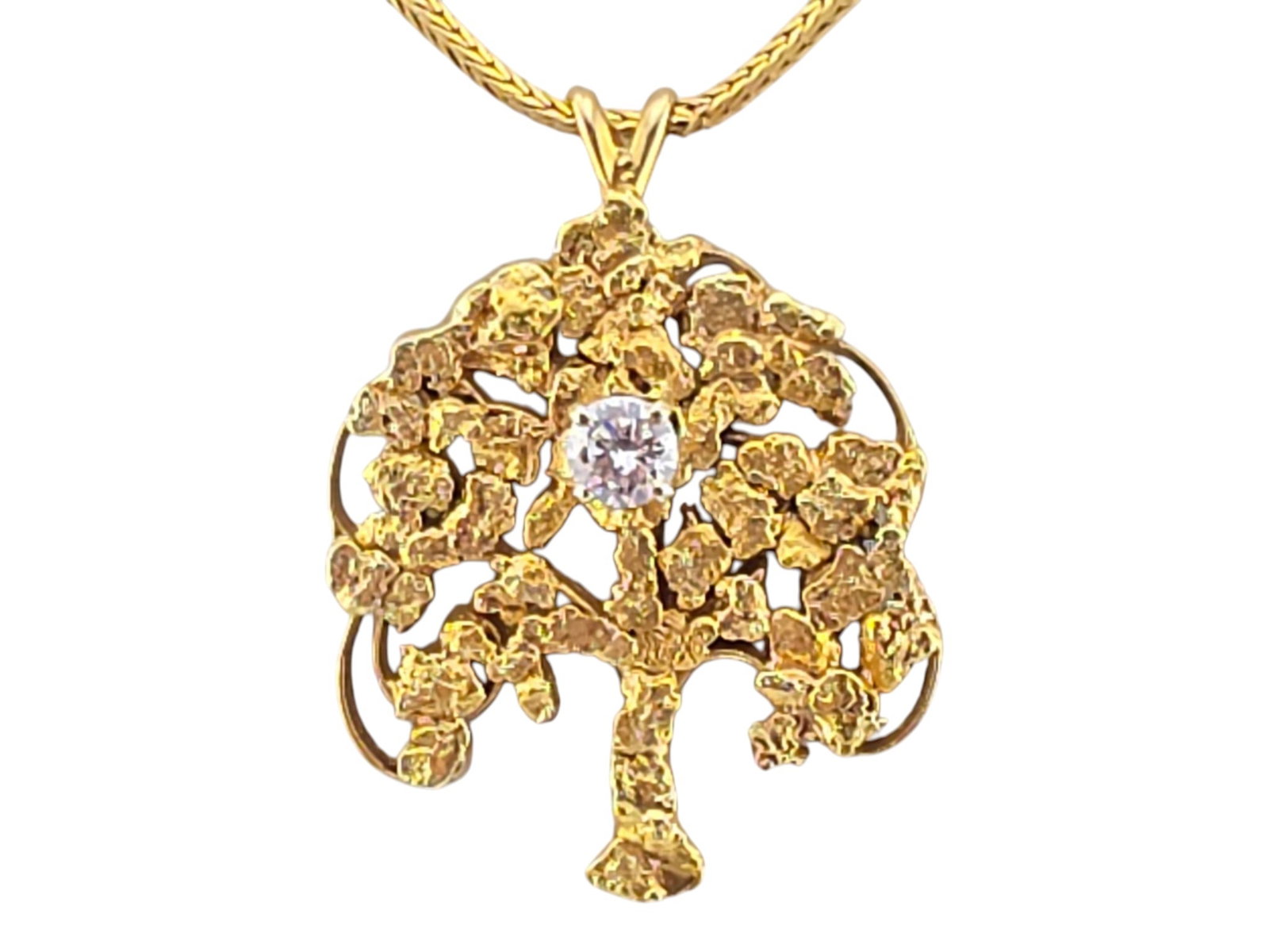Alaskan Gold Nugget Tree of Life Diamond Pendant on 14K Chain: A 10-karat yellow gold tree of life pendant with a gold nugget inlay, embellished with a good quality round diamond of approximately .35 to .40 carats and attached to an 18" 14-karat gold chain. The p