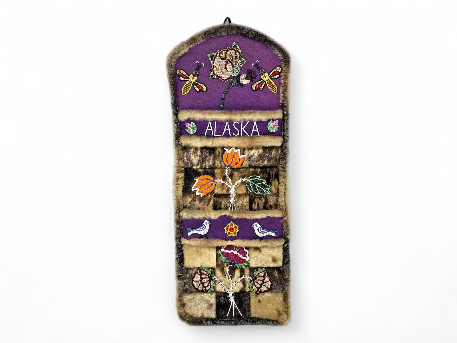Tlingit Beaded Seal Fur Wall Pocket: A Tlingit wall pocket or sewing caddy dating to the first half of the 20th century, crafted from spotted seal fur arranged in alternating checkerboard and striped panels, accented with purple felt and
